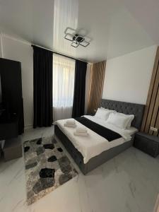 a bedroom with a large bed and a television at IUNIk in Azuga