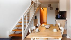 a dining room with a table and chairs and a staircase at Le Bellevue in Xonrupt-Longemer +5 photos
