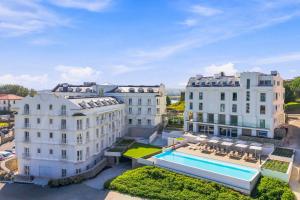 an aerial view of three buildings with a swimming pool at Gran Hotel Suances in Suances