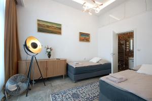 a bedroom with two beds and a fan in it at Libušina Villa in Kutná Hora