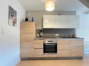 a kitchen with white cabinets and a stove top oven at Le Bellevue in Xonrupt-Longemer