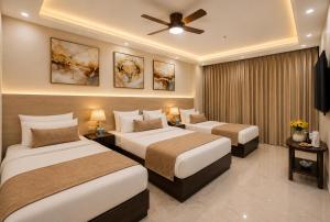 a hotel room with two beds and a ceiling fan at Hotel West Residency Delhi Airport in New Delhi +159 photos