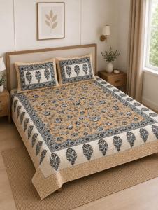 a bed with a quilt on it in a bedroom at Hotel teara in Gwalior
