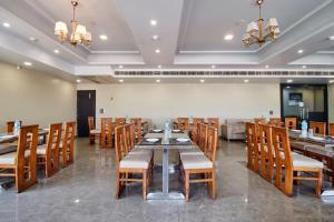 a dining room with a long table and wooden chairs at Treebo Prem Tower in Haldwāni