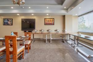 a dining room with tables and a flat screen tv at Treebo Prem Tower in Haldwāni +29 photos