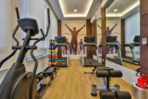 a gym with cardio machines and people in the background at Summit Suítes Hotel Pindamonhangaba in Pindamonhangaba