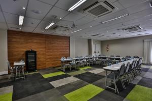 a conference room with tables and chairs in it at Summit Suítes Hotel Pindamonhangaba in Pindamonhangaba