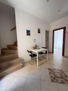a white table and chairs in a room with stairs at Suite 93 in Mola di Bari