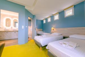 two beds in a room with blue walls at Hostellerie Bon Pasteur in Angers