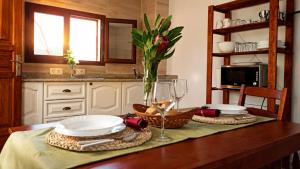 a table with two plates and a glass of wine at Casa Ada con Terraza Panorámica al Roque Bentayga by Canarias Prime Homes in Tejeda