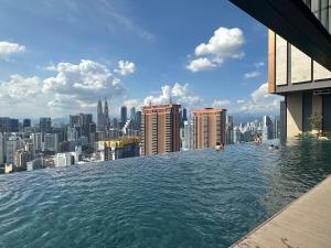 a infinity pool on the roof of a building with a city at Lucentia Residence BBCC Modern City View Stay in Kuala Lumpur