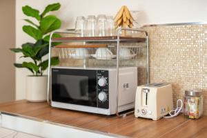 a microwave and a toaster on a kitchen counter at Turtle Tales-Tao Khon in Thai Muang
