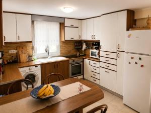 a kitchen with a table with a plate of bananas on it at The Secret Garden Peraia in Perea