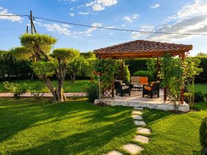 a gazebo with a table and chairs in a yard at The Secret Garden Peraia in Perea