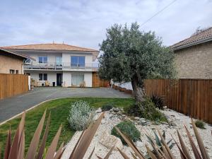 a house with a fence and a tree in the yard at Appartement Bassin d' Arcachon in La Teste-de-Buch