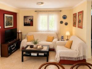 a living room with a couch and a table at The Secret Garden Peraia in Perea