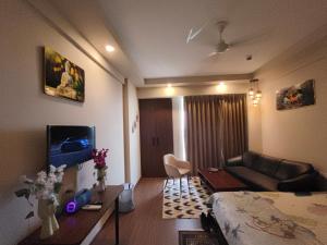 a living room with a bed and a couch in a room at Sunlit Omaxe ITC, Greater Noida in Greater Noida