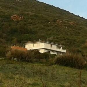 um edifício branco no lado de uma colina em Chicco Frau appartamenti trattati con OZONO em Fluminimaggiore
