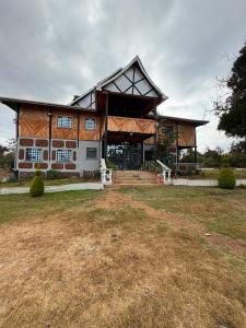 a large building with a gambrel roof at EarthShip Log Cabin, Timau in Nanyuki
