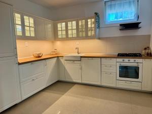 a kitchen with white cabinets and a sink at SAN Apartments Near Belgrade Airport in Surčin