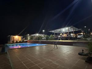 a swimming pool at night with a building in the background at Senmonorom in Senmonorom