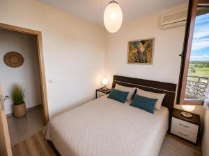 a bedroom with a bed with blue pillows and a window at Spacious 2 bedroom apartment in Balchik