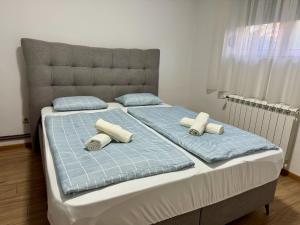 a bedroom with two beds with pillows and a headboard at SAN Apartments Near Belgrade Airport in Surčin