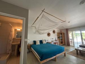 a bedroom with a bed with a blue comforter at BnBBonaire near the ocean in Kralendijk +106 photos