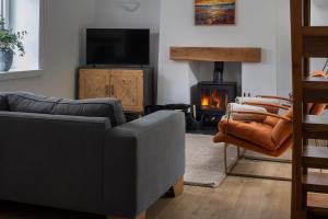 a living room with a couch and a fire place at Bayholme House in Oxwich