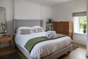 a bedroom with a large bed with towels on it at Bayholme House in Oxwich