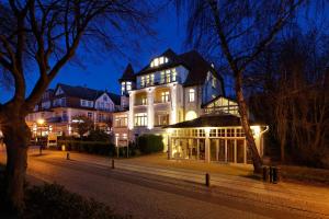 a large white building with lights on at night at Strandresidenz Villa Verdi in Kühlungsborn