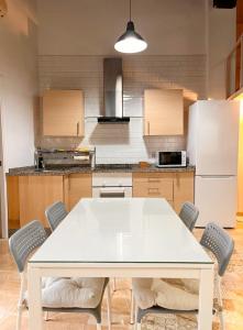 a kitchen with a white table and chairs at Loft Boutique con Encanto in Montilla +6 photos