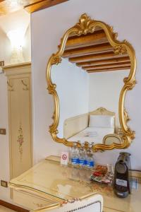 Ein Spiegel steht auf einem Tisch mit Wasserflaschen. in der Unterkunft Hotel Orion in Venedig + 28 Fotos