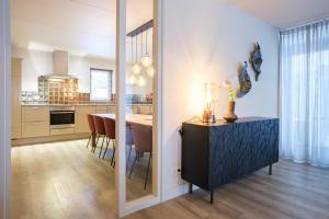 a kitchen and dining room with a table and chairs at Kampeerdorp de Zandstuve - Kindvriendelijke Vakantiepark in Rheeze
