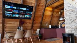 a bar with chairs and a tv on the wall at Horizons by PeaksView Chalets in Žabljak