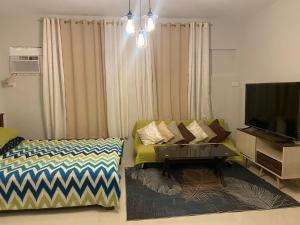a living room with a couch and a flat screen tv at spacious condo unit 1P olvera residences in Bacolod