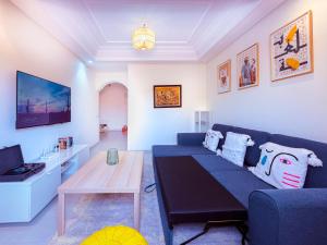 a living room with a blue couch and a table at Jardin Yves Chic 2 bedrooms - AC - Parking in Marrakesh