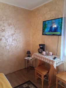 a room with a table with a tv on the wall at Casa Lav in Sinaia
