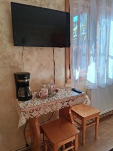 a table with a coffee maker and a television on a wall at Casa Lav in Sinaia +16 photos
