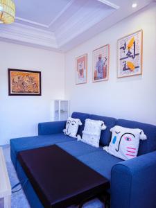 a blue couch in a living room with pillows on it at Jardin Yves Chic 2 bedrooms - AC - Parking in Marrakesh