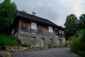 an old stone building with white windows on it at Dom Na Biegunach in Cięcina