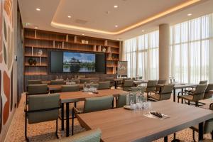 a conference room with tables and chairs and a flat screen tv at Van der Valk Hotel Woerden in Woerden