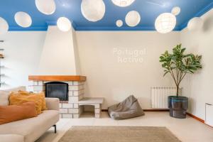 a living room with a couch and a fireplace at Portugal Active Cabedelo Beach Lodge - Heated Pool in Viana do Castelo
