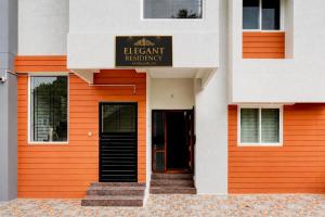 an orange and white building with a sign on it at Vandalur Stay's Inn in Vandalūr