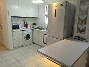 a kitchen with a refrigerator and a washing machine at Philly's sea side apartment in Agios Ioannis Pelio