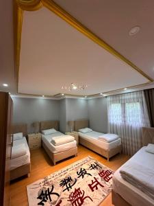 a room with three beds with writing on the ceilings at Koç Motel in Uzungöl
