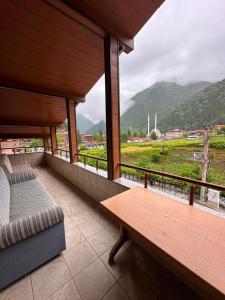 a balcony with a bench and a view of a mountain at Koç Motel in Uzungöl