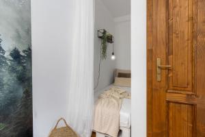 a bedroom with a bed and a wooden door at Apartmán TICHO - Ostrůvek in Lesná