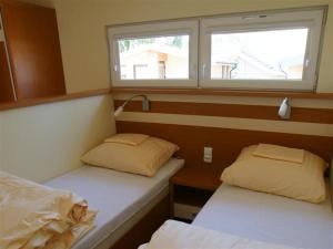 two beds in a small room with a window at OW Viva in Jantar +19 photos