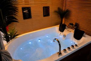 a bath tub with a faucet in a bathroom at Maison LOVEROOM 70m2 L'entre Nous in Grenoble